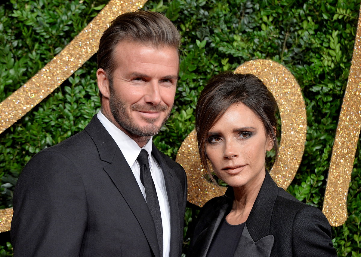 David und Victoria Beckham posieren vor grüner Wand