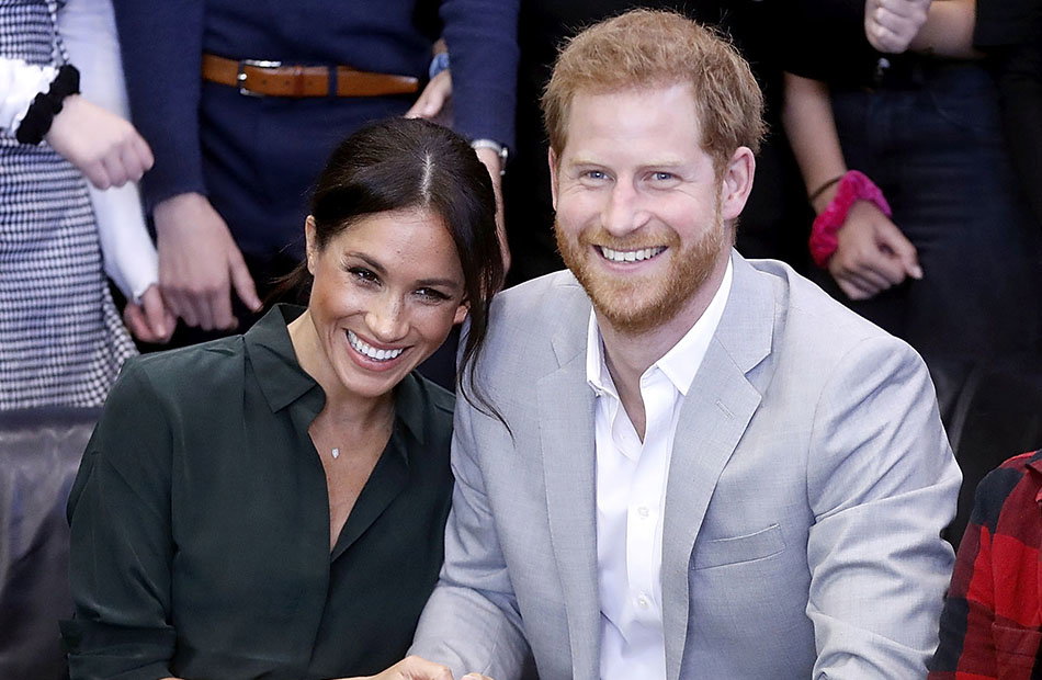 Herzogin Meghan lehnt sich lachend an Prinz Harry