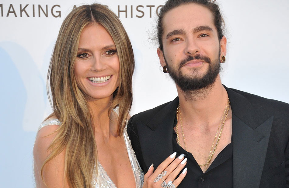 Heidi Klum legt lächelnd ihre Hand auf Tom Kaulitz' Brust