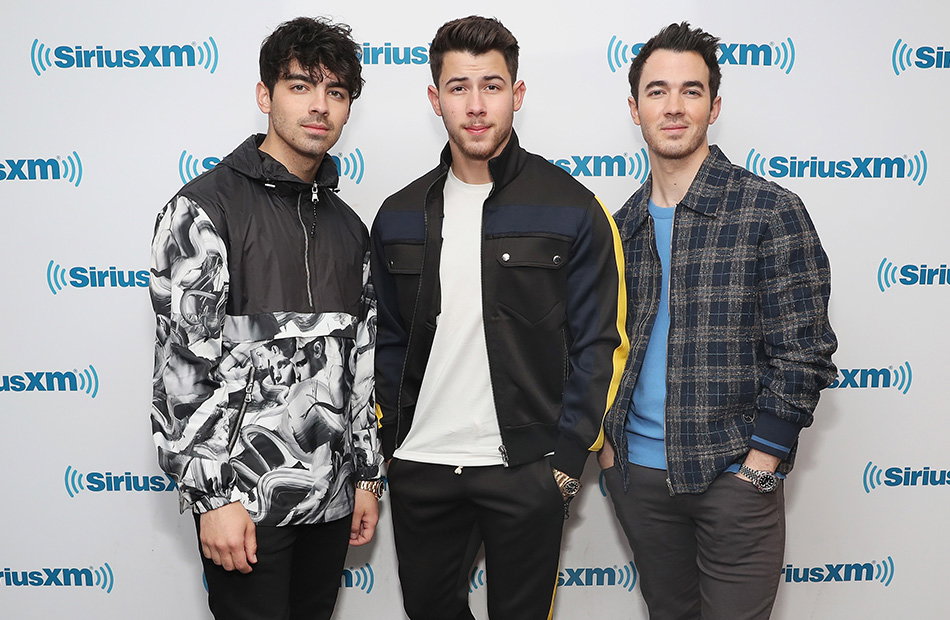 Die Jonas Brother, Joe, Nick und Kevin Jonas lächelt leicht