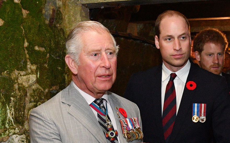 König Charles und Prinz William schauen schockiert und ernst, dahinter Prinz Harry