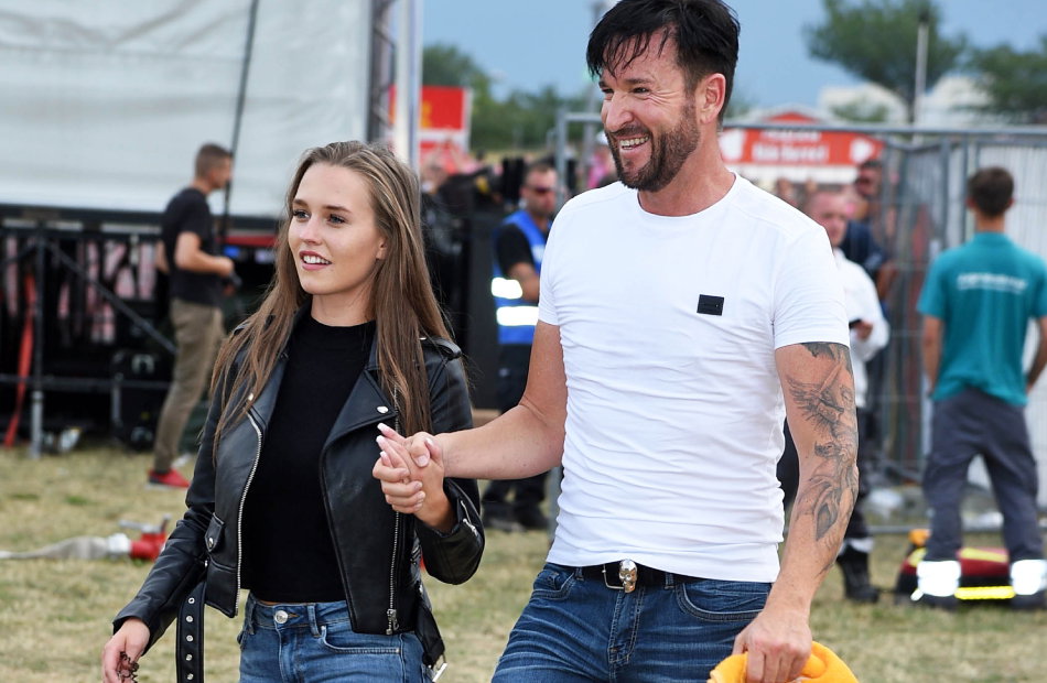 Laura Müller und Michael Wendler laufen Hand in Hand über eine Wiese und grinsen