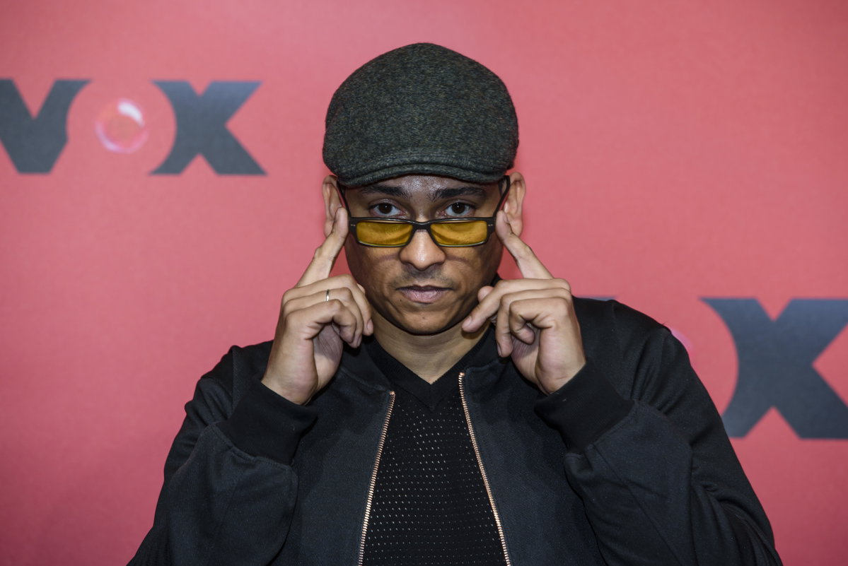 Xavier Naidoo hält mit den Händen seine Sonnenbrille und trägt eine Mütze