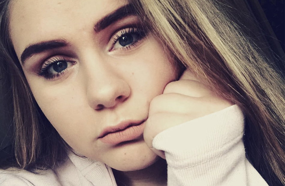 Estefania guckt traurig auf Selfie.