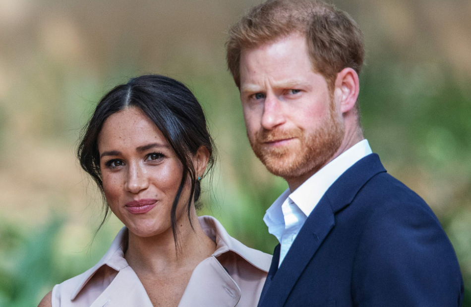 Herzogin Meghan schmunzelt und Prinz Harry guckt ernst