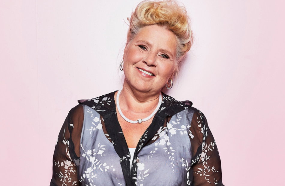 Silvia Wollny lächelt vor rosa Wand