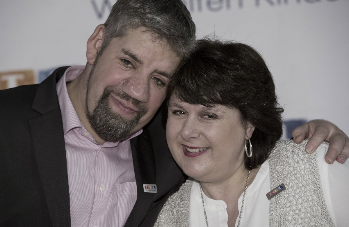Uwe und Iris Abel gucken fröhlich und nehmen sich in den Arm
