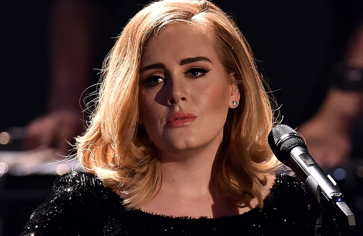 Adele guckt traurig mit Mikrofon.
