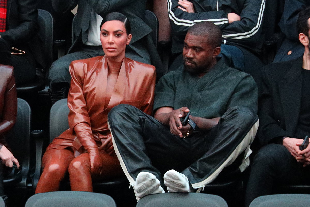 Kim Kardashian und Kanye West sitzen zusammen und sehen unglücklich aus