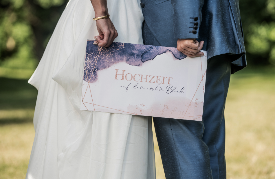 Brautpaar mit einem "Hochzeit auf den ersten Blick"-Schild