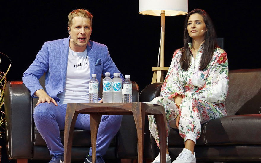 Oliver und Amira Pocher sitzen in Sesseln auf der Bühne