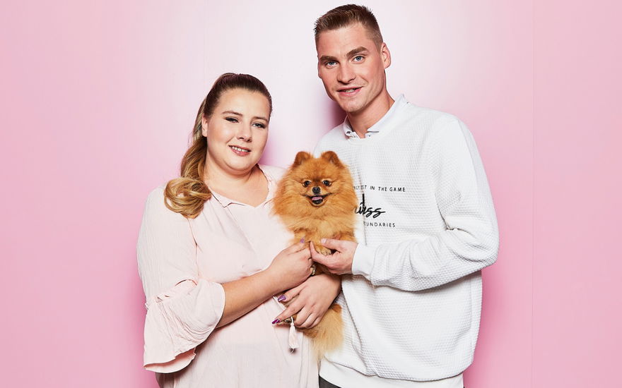 Sarafina und Peter Wollny mit Hund Feivel auf dem Arm vor einer pinken Wand