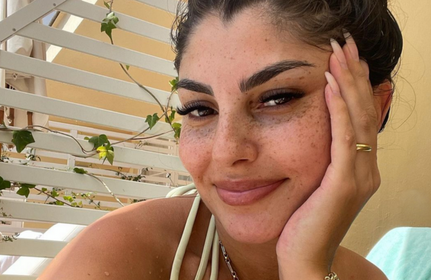 Yeliz Koc stützt den Kopf in die Hand und lächelt