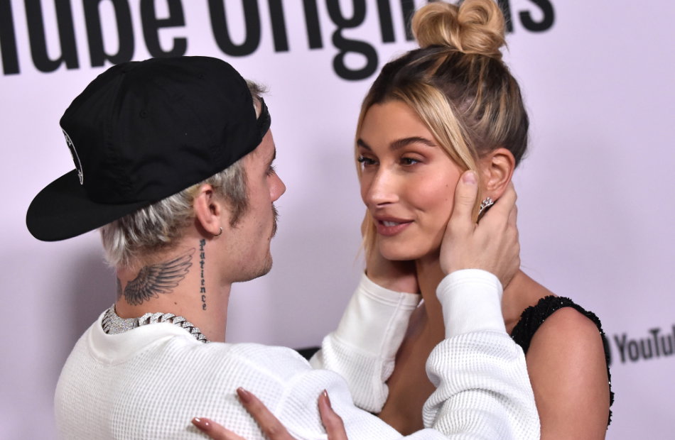 Justin hält Haileys Gesicht in seinen Händen, während sie ihn anlächelt.