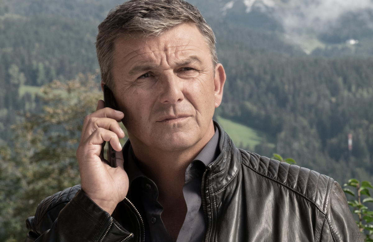 "Der Bergdoktor" Hans Sigl vor Alpen-Panorama - er telefoniert ernst
