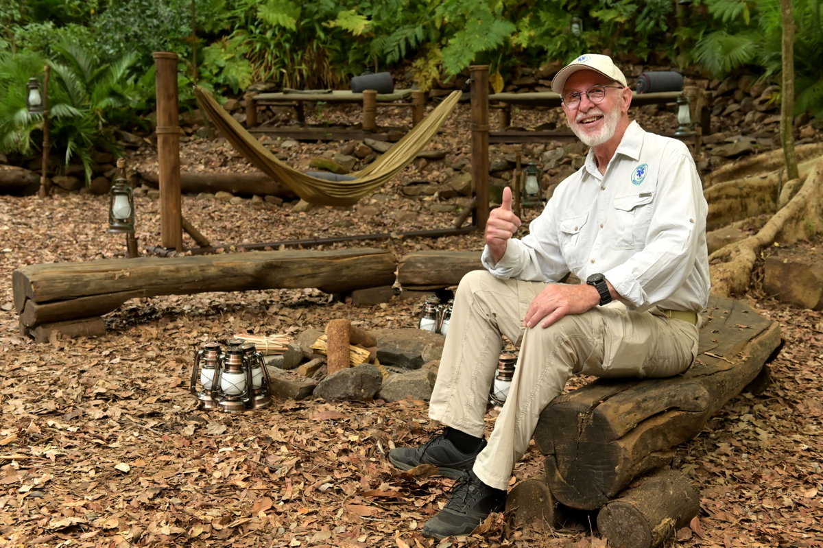 Dr. Bob sitzt auf Baumstamm im Dschungelcamp
