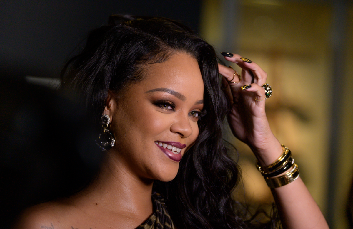 Rihanna lacht und greift sich ins Haar