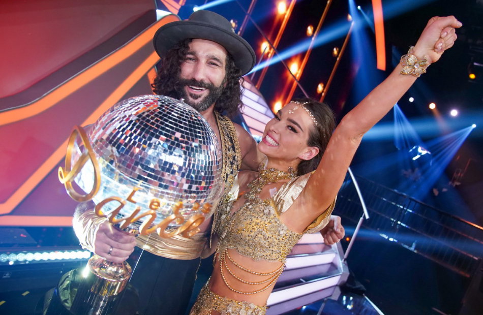 Massimo und Lili Paul-Roncalli lächeln in die Kamera und halten den Let's Dance Gewinner Pokal.
