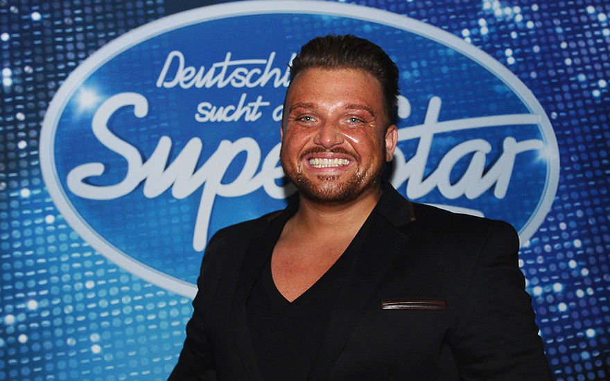 Menowin Fröhlich vor dem DSDS-Logo