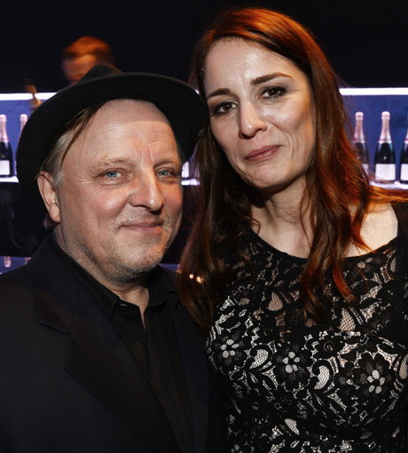 Fluppe in der Hand, Hut auf dem Kopf - und eine echte Lady im Arm: Axel Prahl mit seiner Freundin Silja auf einer Party in Berlin