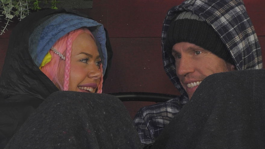 Nina Bridney und Christian Lell sitzen bei "Promi Big Brother" eingekuschelt nebeneinander und lächeln sich an